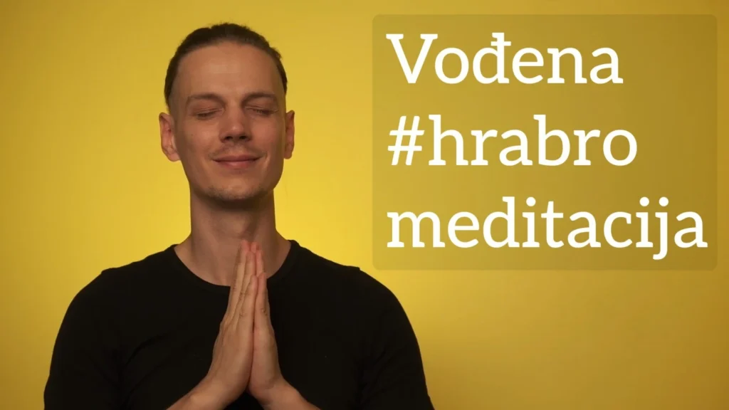 Luka Šolta sa sklopljenim rukama s mirnim izrazom lica, u crnoj majici ispred zlatne pozadine. Natpis "Vođena #hrabro meditacija"